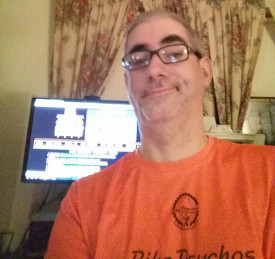 photo of Jim, looking proud, in front of a monitor displaying the original Pie Factory Podcast web site